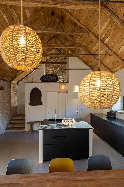 - une cuisine avec deux lumières, une table et des chaises dans l'établissement Les Terrasses de Majorac, à Bozouls