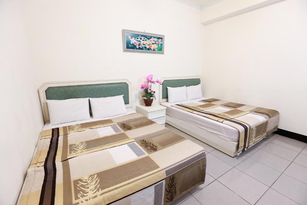 two beds in a room with white walls at Yuan-Yee Homestay in Jiufen
