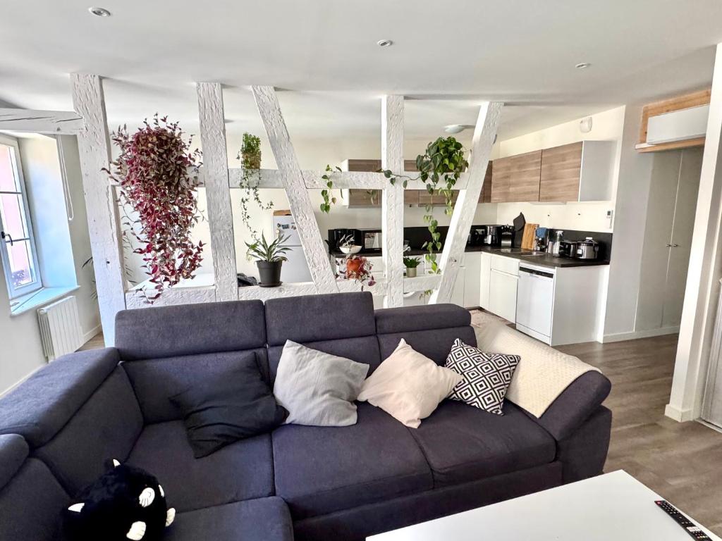 a living room with a blue couch and a kitchen at Grand et lumineux 2 pièces avec climatisation en zone pietonne in Haguenau