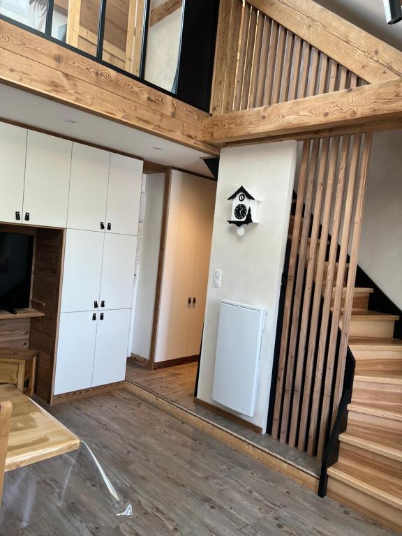 une chambre avec des armoires blanches et un escalier dans l'établissement la vallée des marmottes, à La Bresse