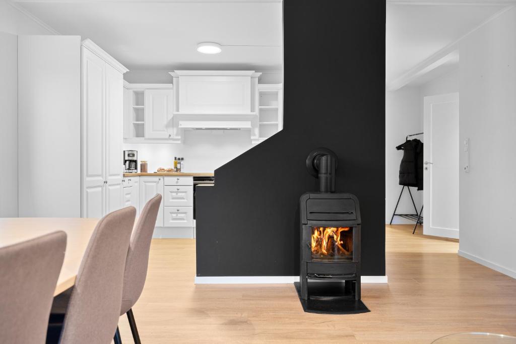 a fireplace in a living room with a table and chairs at Arctic Aurora Apartment I SAUNA I Family & Groups in Tromsø