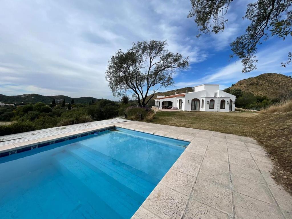 a swimming pool in front of a house at Casa en Potrerillo de Larreta Magicas Vistas in Alta Gracia