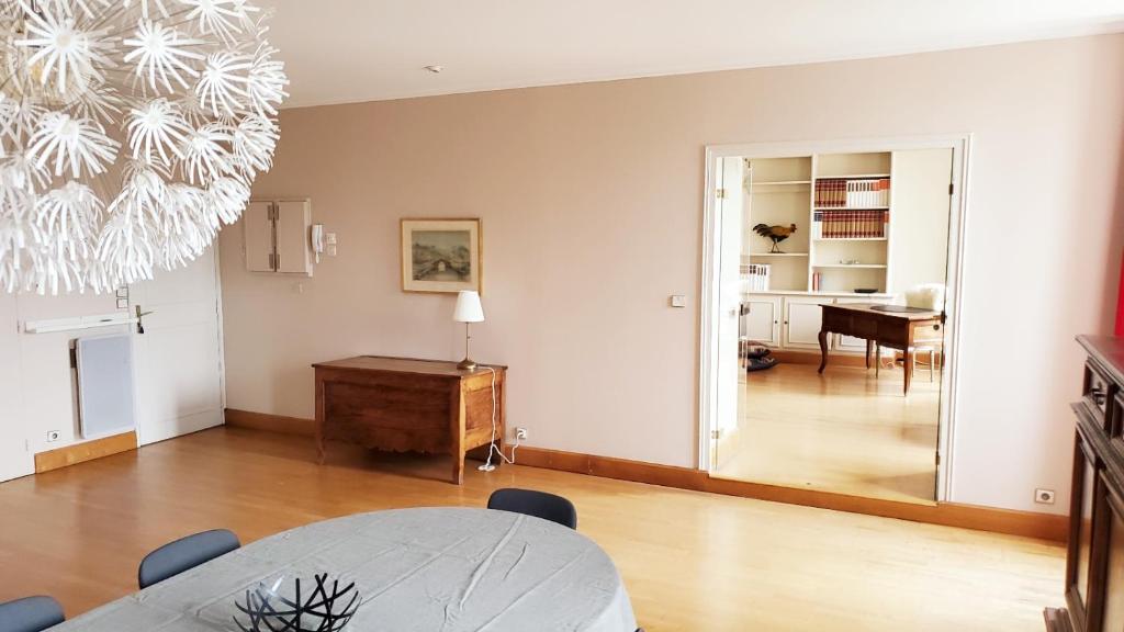 un salon avec une table et un bureau dans l'établissement L'Appart Du Vieux Port, à La Rochelle