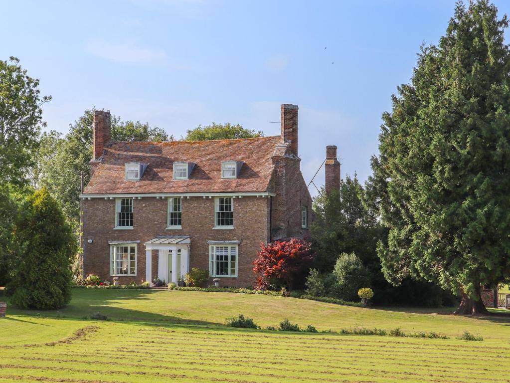 an old brick house on a green lawn at Goss Hall in Canterbury