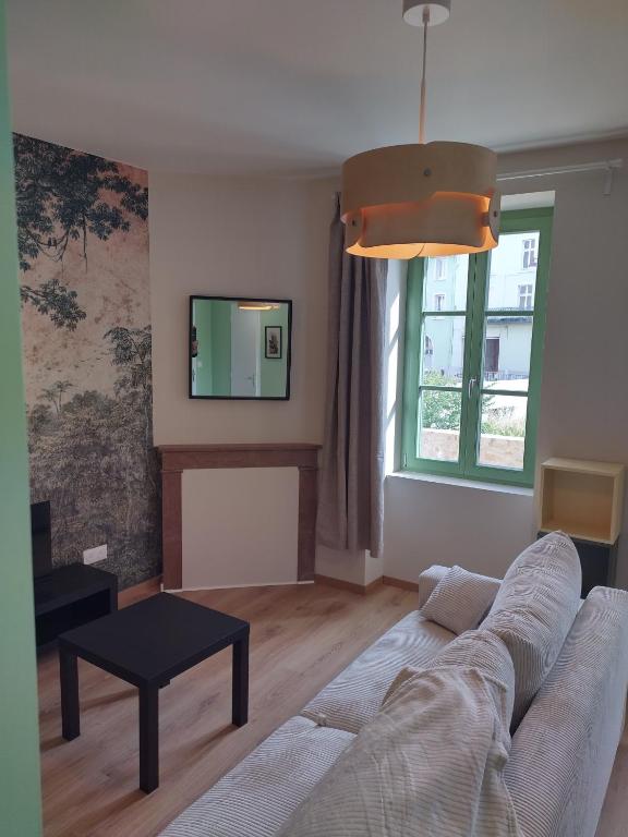 un salon avec un canapé et une télévision dans l'établissement Appartement neuf, tout confort, à Issoire