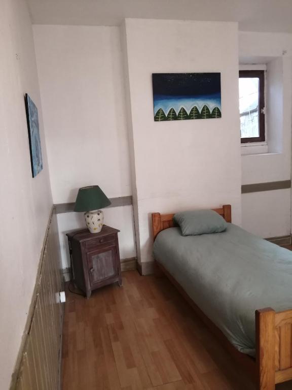 une chambre avec un lit et une table avec une lampe dans l'établissement Studio Art Lumineux Evasion Sérénité Doué en Anjou, à Doué-la-Fontaine