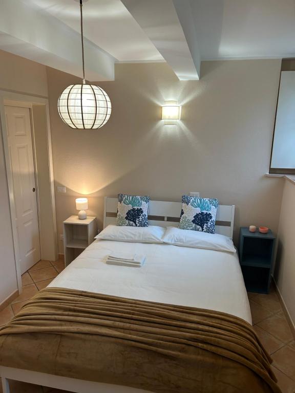 a bedroom with a large white bed with blue pillows at Serena's turistic apartament in Parma