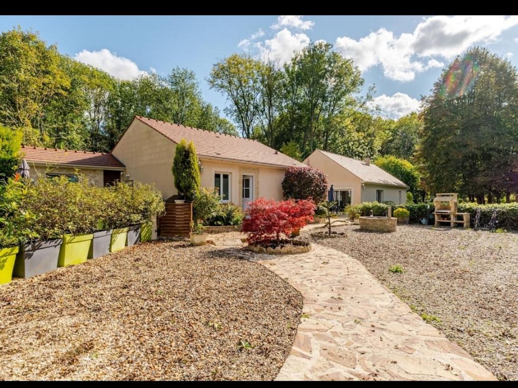 a house with a gravel driveway in front of a yard at Maison au bout du chemin in Gouvieux