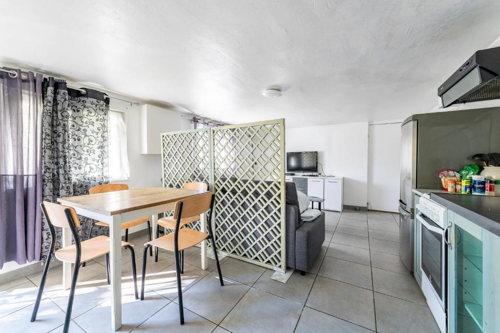 a kitchen and dining room with a table and chairs at Appartement Cosy - Proche Disneyland - Paris - RER in Noisy-le-Grand