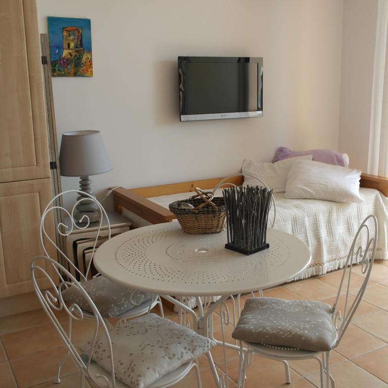 une table et des chaises dans une chambre avec un lit dans l'établissement Residence CORSE AZUR AJACCIO, à Ajaccio