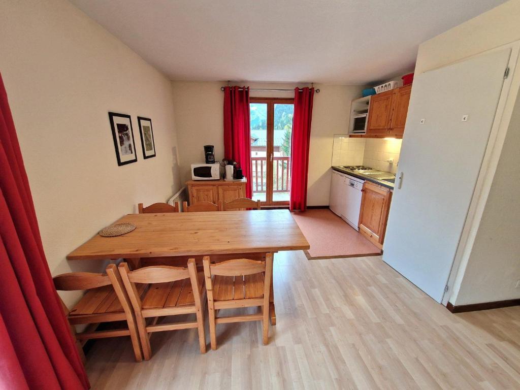 Il comprend une cuisine et une salle à manger avec une table en bois. dans l'établissement Appartement 3 pièces, 4/6 pers, balcon, proche pistes à Valfréjus - FR-1-265-183, à Valfréjus