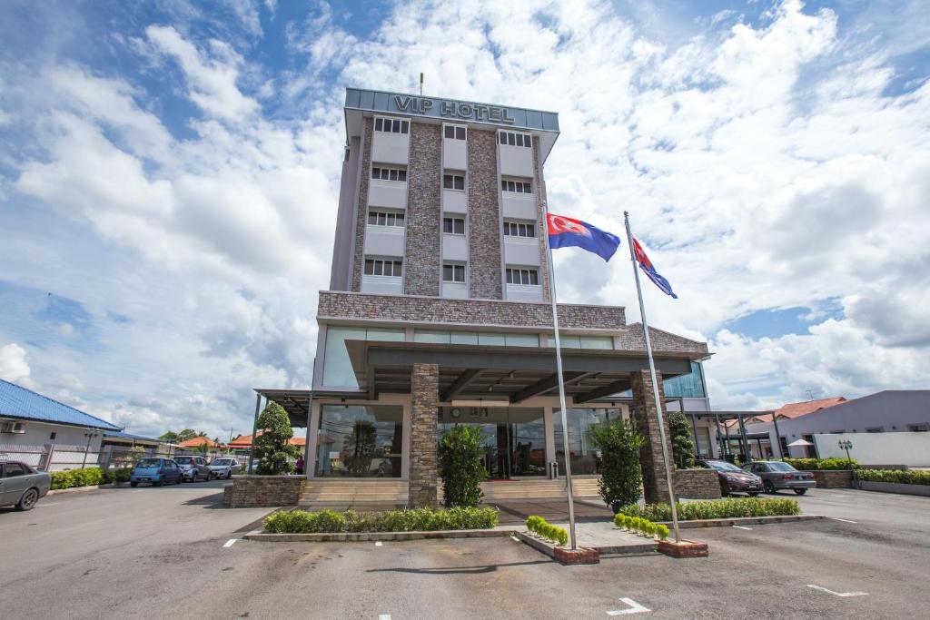a hotel building with two flags in a parking lot at VIP Hotel Segamat in Segamat