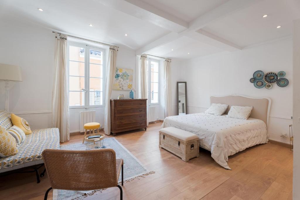 a white bedroom with a bed and a couch at Nid d amour en plein coeur des clochets in Le Beausset