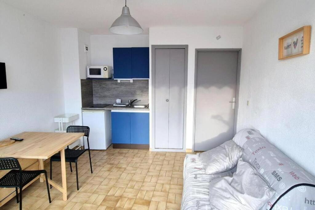 Il dispose d'une cuisine et d'un salon avec un canapé et une table. dans l'établissement Studio Cosy ,2pers, cosy douillet, 3mn mer, à La Grande Motte