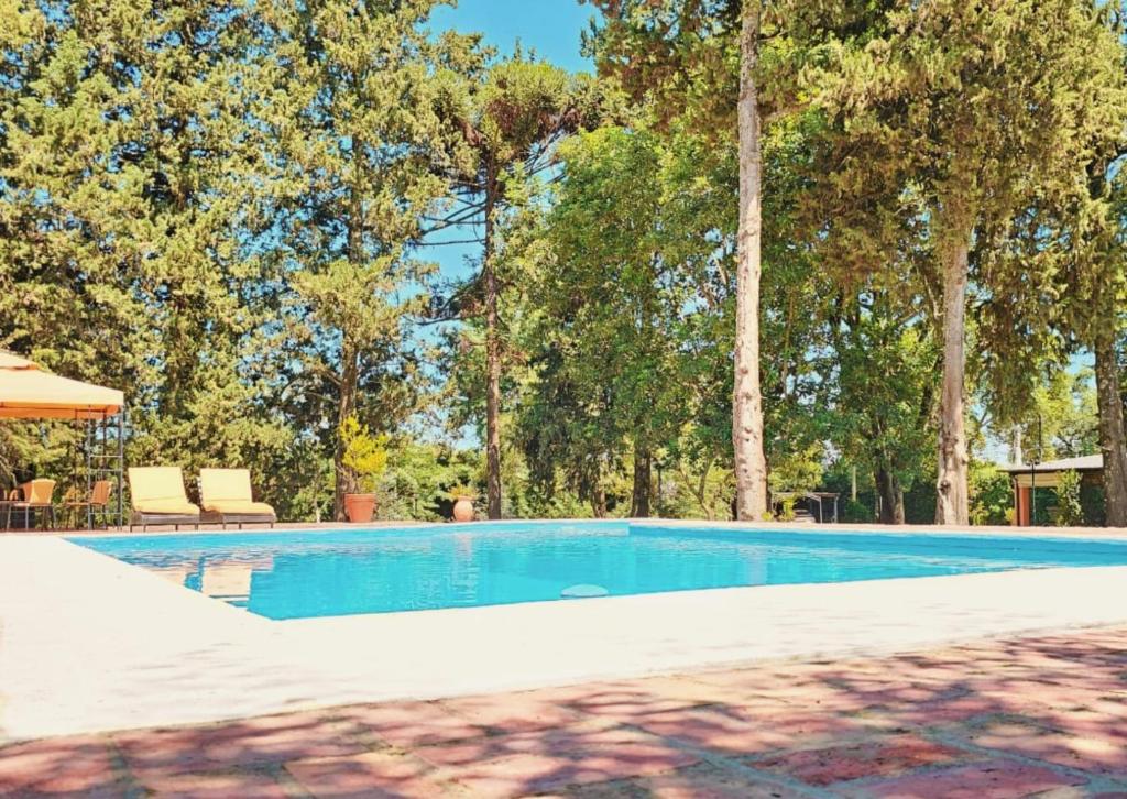a swimming pool with trees in the background at Villa Arbolada in San Lorenzo