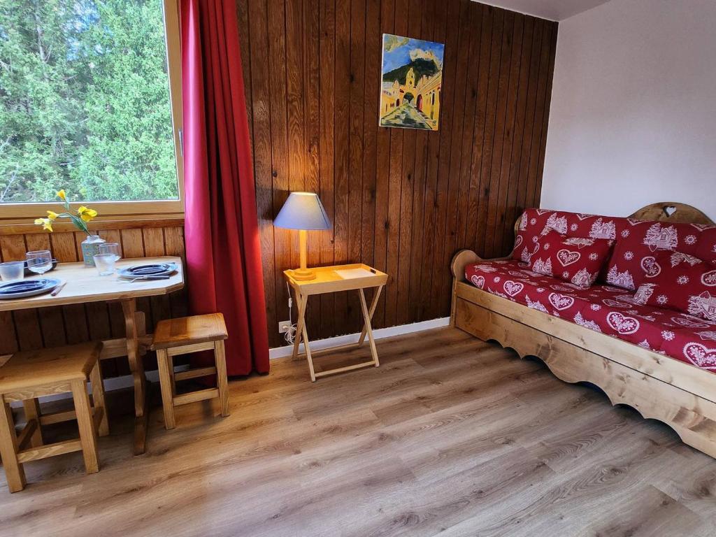 un salon avec un canapé rouge et une table dans l'établissement Studio 2 pers à Avoriaz - Quartier des Dromonts - Pied des pistes - Cosy et tout équipé - FR-1-633-16, à Avoriaz