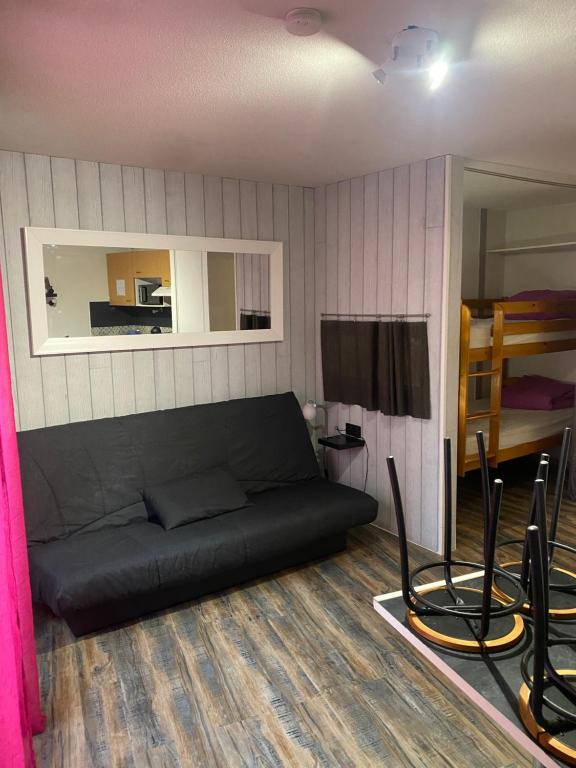 - un salon avec un canapé noir et un lit dans l'établissement Résidence Bellevue Cauterets, à Cauterets