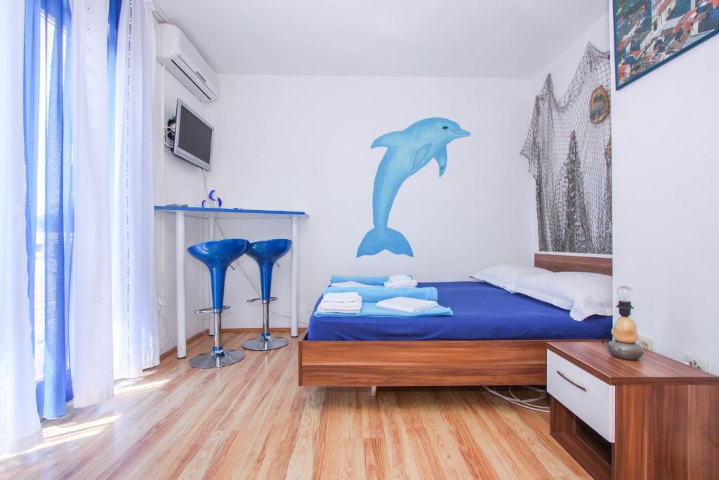 a bedroom with a bed with a dolphin on the wall at Apartments Ars Vivendi in Trogir