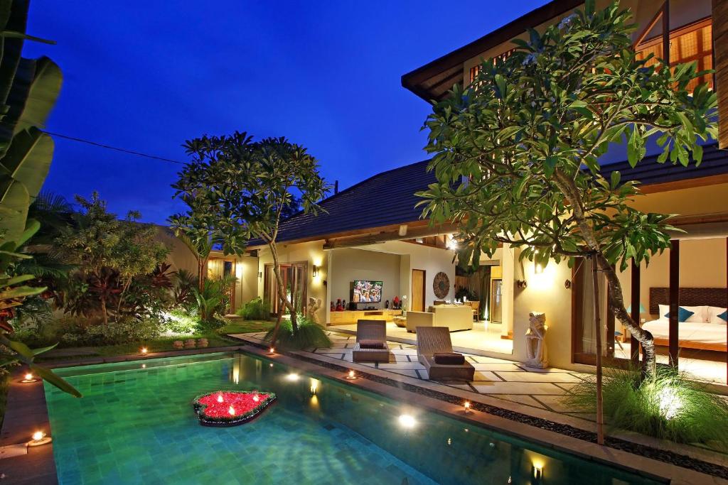 an image of a villa with a swimming pool at night at Desa Di Bali Villas in Kerobokan