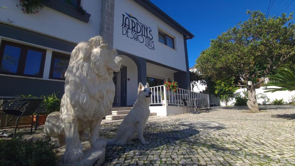 eine Statue eines Löwen und eines Hundes vor einem Gebäude in der Unterkunft Hostel Jardins de São Luís in Setúbal