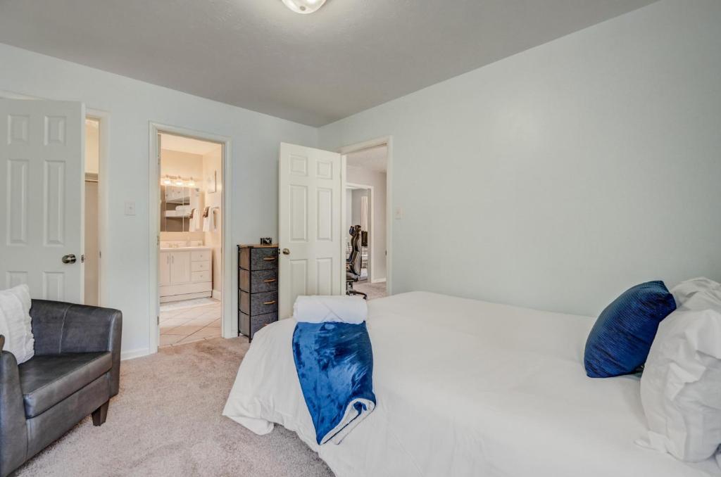 ein Schlafzimmer mit einem großen weißen Bett und einer Couch in der Unterkunft Steps to Downtown Eateries & Bars - With Fire Pit! in Colorado Springs