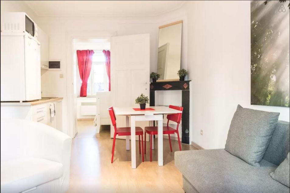 a living room with a table and red chairs at Cool Central Apartment in Brussels