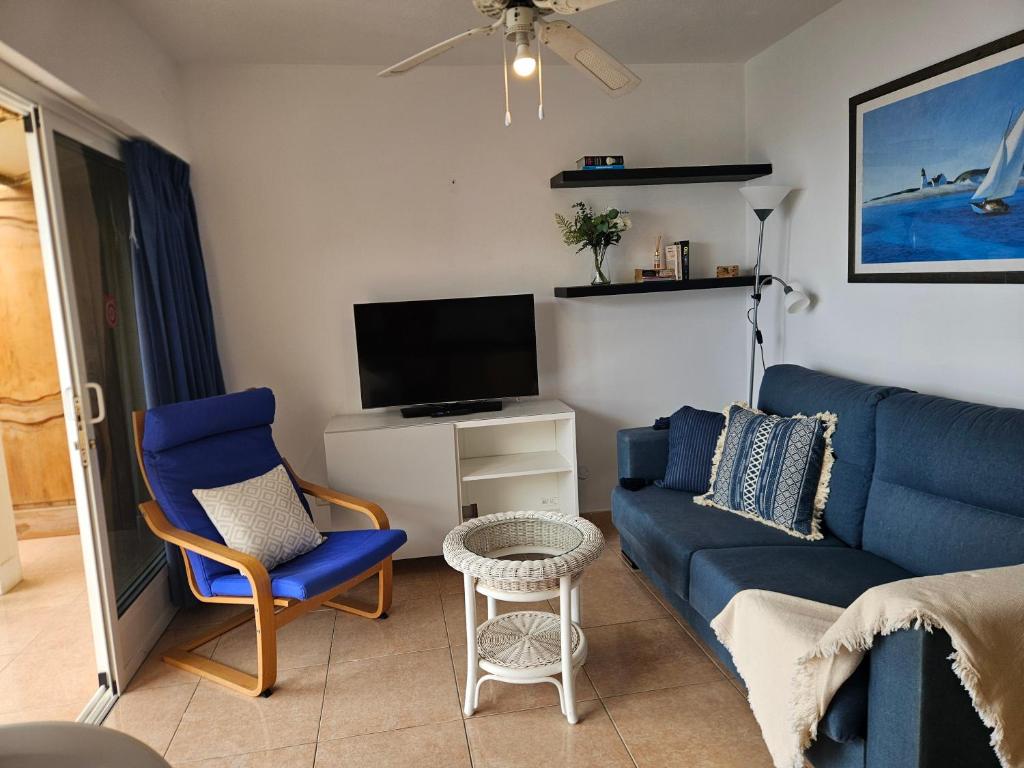 salon z niebieską kanapą i telewizorem w obiekcie Flipper Top Suites w mieście San Agustin