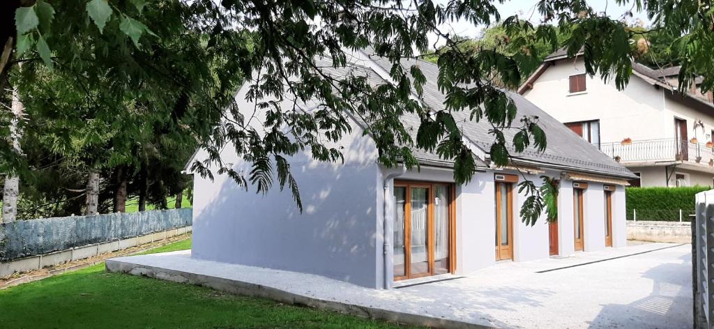 a white building with windows in a yard at Maison familiale à Gerde in Gerde