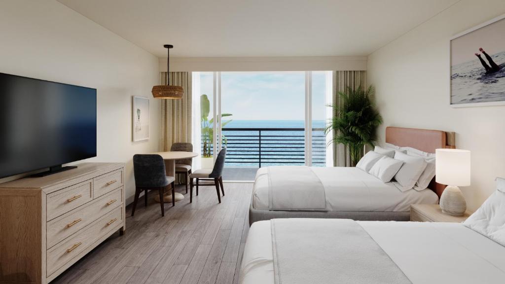 a hotel room with two beds and a flat screen tv at Ocean Reef Resort in Myrtle Beach