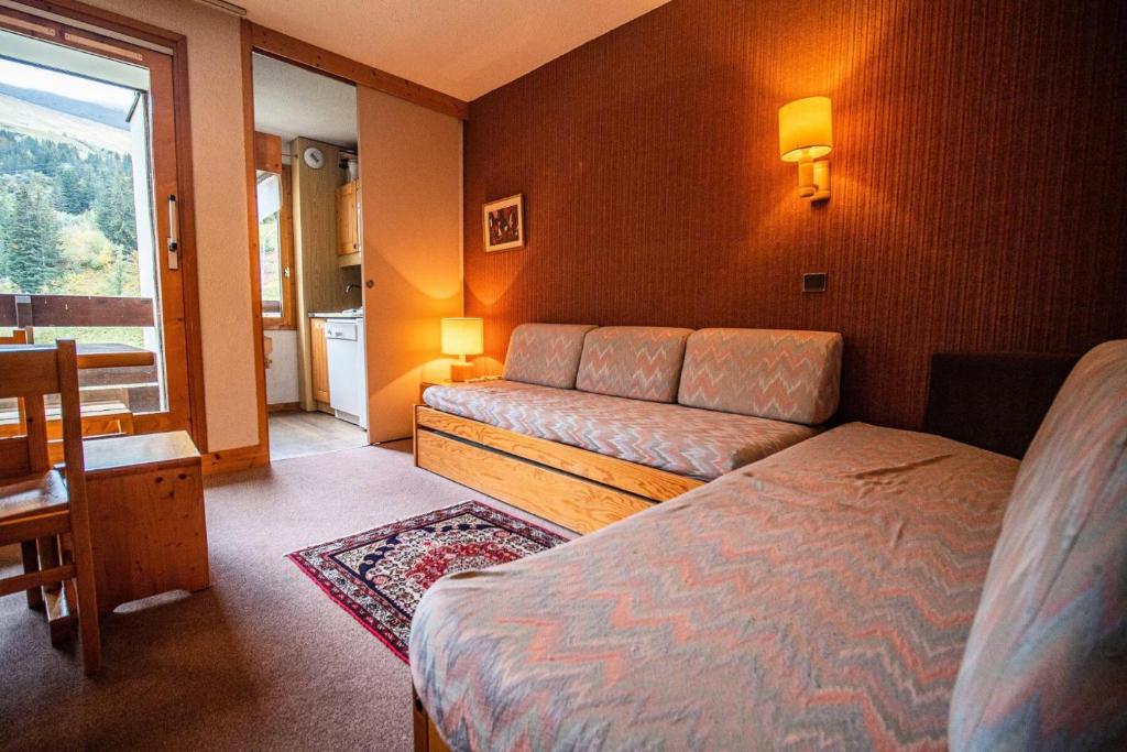 une chambre d'hôtel avec un lit et un canapé dans l'établissement Résidence Mucillon G - MUCILLON 5 MAE-3761, à Valmorel