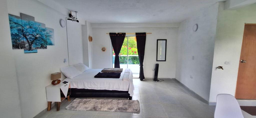 a white bedroom with a bed and a window at OSIMiRI JAMAICA II-Piscina, naturaleza mágica in San Rafael
