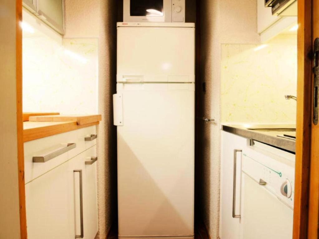 La cuisine est équipée d'un réfrigérateur blanc et d'un four micro-ondes. dans l'établissement Résidence Les Roches - deux pièces à proximité des pistes MAE-6331, à Aime La Plagne