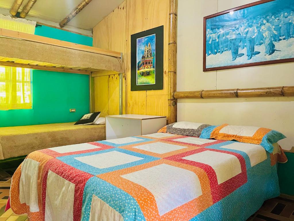 a bedroom with a bed with a colorful quilt at Los Gulungos Hostel in Jardin