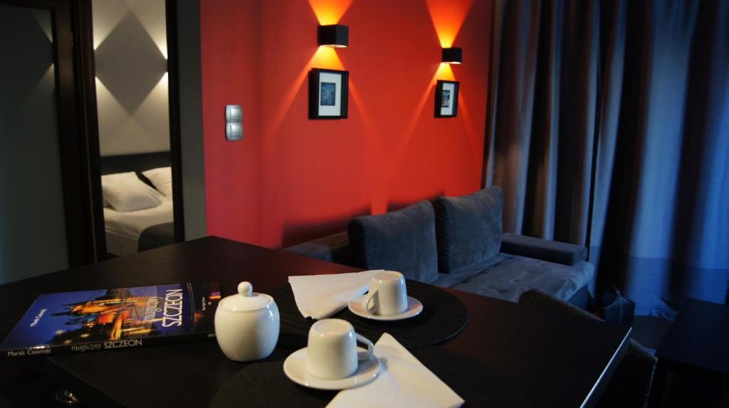 a room with a black table and a red wall at Art Apartment Szczecin in Szczecin