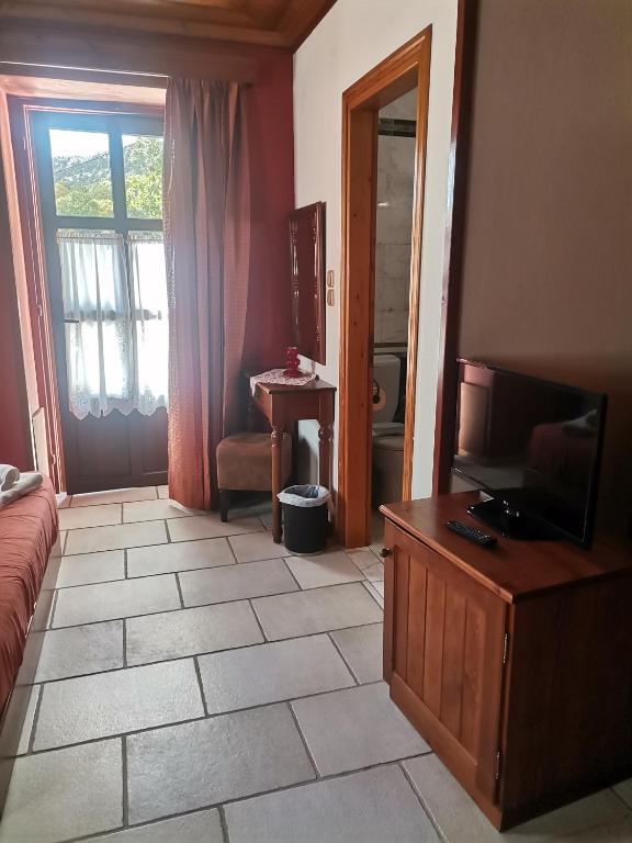 sala de estar con TV y suelo de baldosa. en Konstantinou & Elenis, en Monodendri