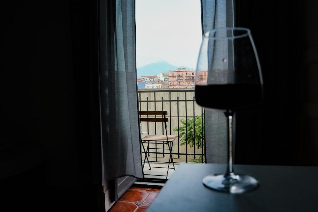 una copa de vino sentada en una mesa frente a una ventana en Catania Vibes, en Catania