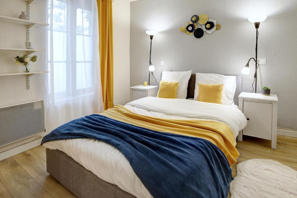 - une chambre dotée d'un grand lit avec des draps jaunes et bleus dans l'établissement Le Soleil Bleu, à Nîmes