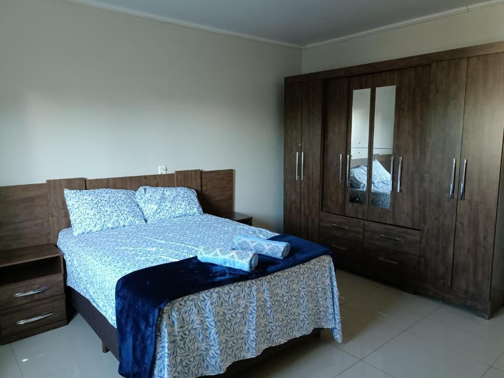 a bedroom with a bed and a wooden cabinet at Para Família - privacidade e lazer próximo ao lago de Itaipu in Foz do Iguaçu