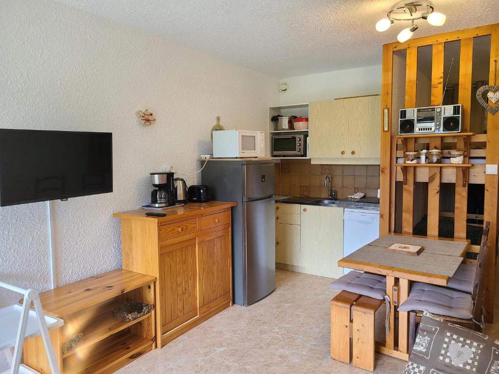 une petite cuisine avec un réfrigérateur et une table dans l'établissement Studio cabine confortable proche pistes ski, 4 pers. - FR-1-689-147, à Villard-de-Lans