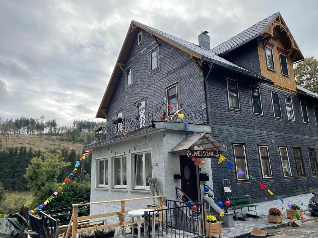 a large black house with a porch at Boutique Hotel Am Bahndamm in Wallendorf