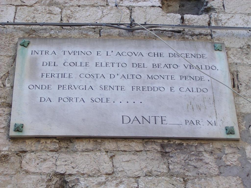 a sign on the side of a brick wall at Angolo di Porta Sole in Perugia