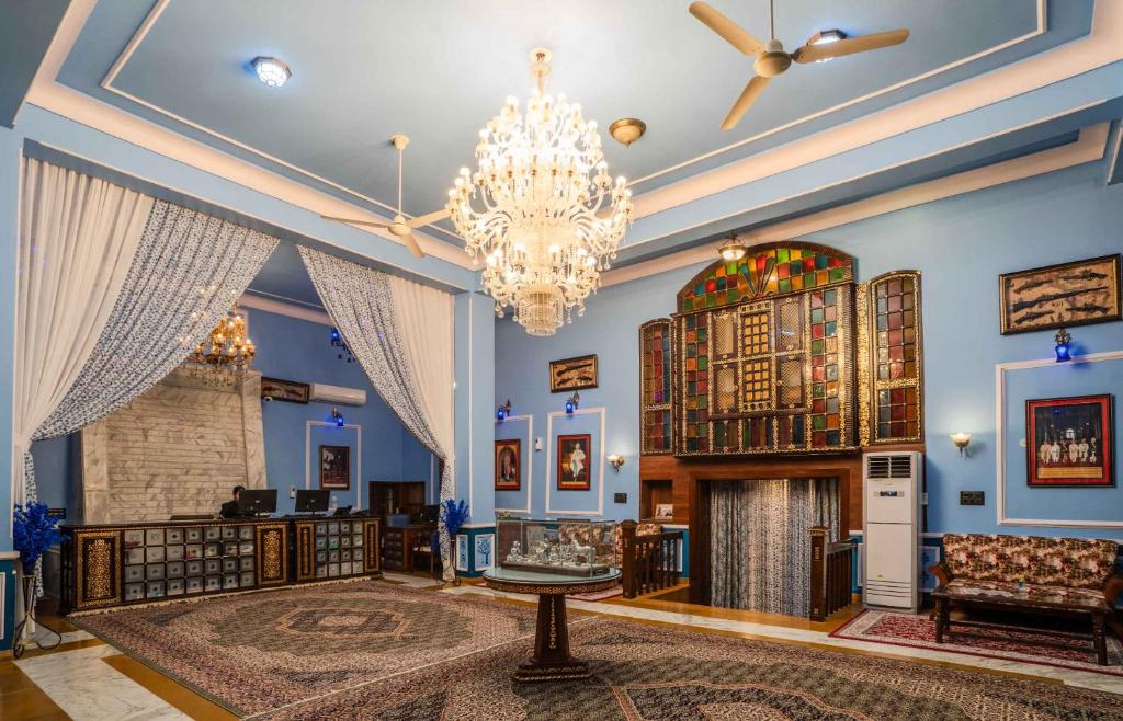 a living room with a chandelier and a fireplace at The Kurki Heritage in Jaipur
