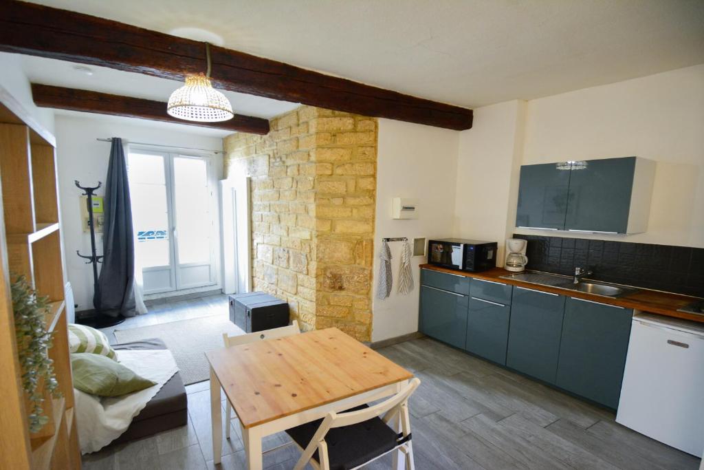- une cuisine avec une table en bois dans une chambre dans l'établissement Agora, au cœur historique, à Montpellier