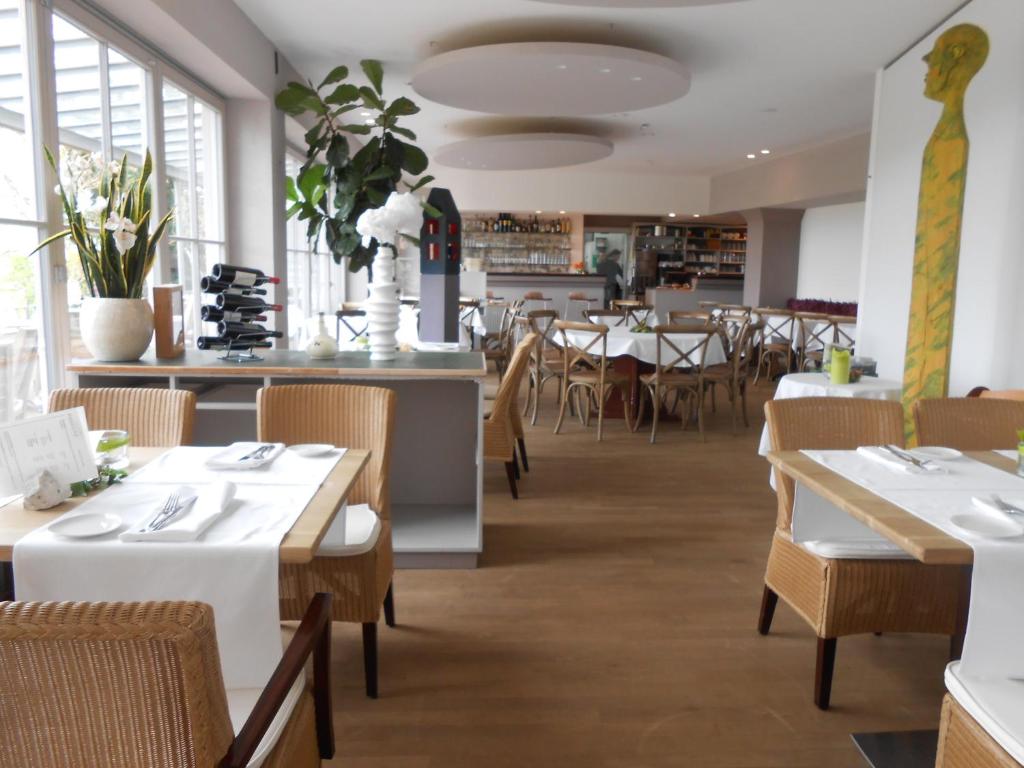 uma sala de jantar com mesas, cadeiras e janelas em aussicht bio hotel restaurant cafe em Neuburg an der Donau