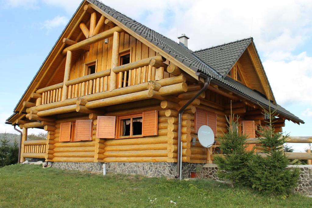 uma cabana de madeira com um telhado preto em Zrubová Chata Sylvester em Oravská Lesná