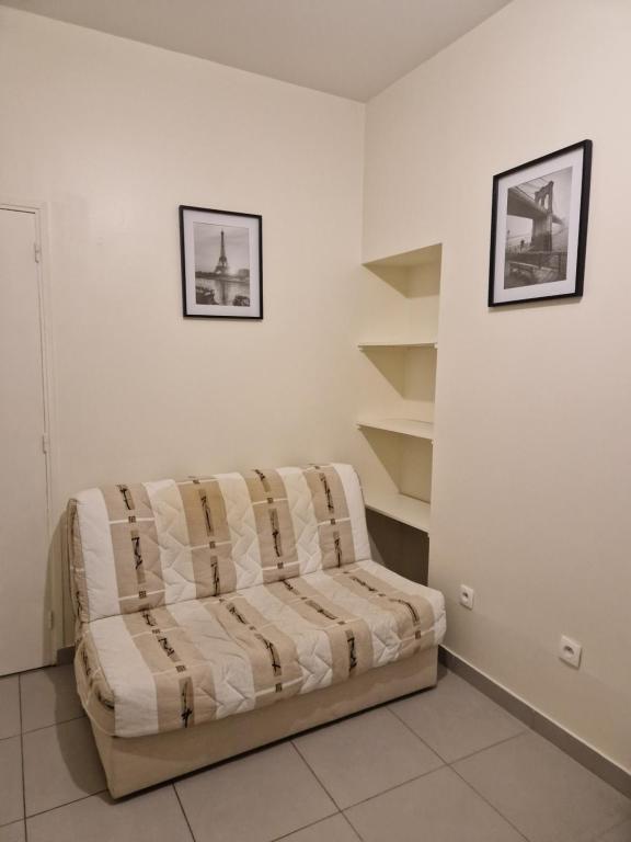 un canapé dans une pièce avec des étagères dans l'établissement Studio pour 2 voyageurs, à Saint-Denis