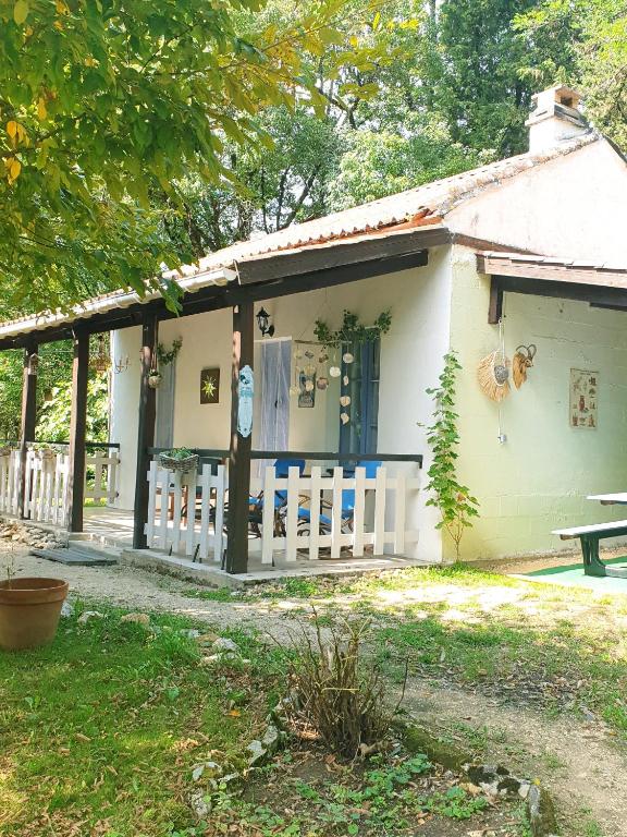 une maison blanche avec une clôture devant dans l'établissement Gite Le Petit Bonheur, à Soturac