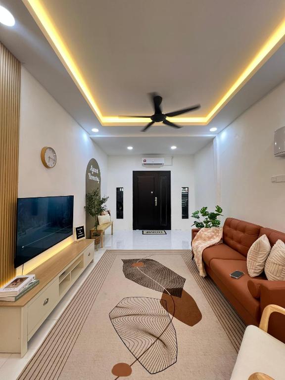 a living room with a couch and a flat screen tv at Ayaani Homestay in Kuala Pilah