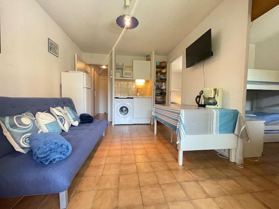 un salon avec un canapé bleu et une cuisine dans l'établissement Cap tranquillité, à Six-Fours-les-Plages