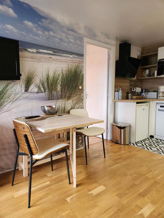 une cuisine et une salle à manger avec une table et des chaises dans l'établissement Appartement Riva Bella 2 pièces à 200 m de la mer, à Ouistreham
